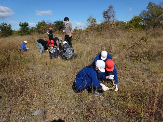 担任の先生と汗を流して作業する５年生